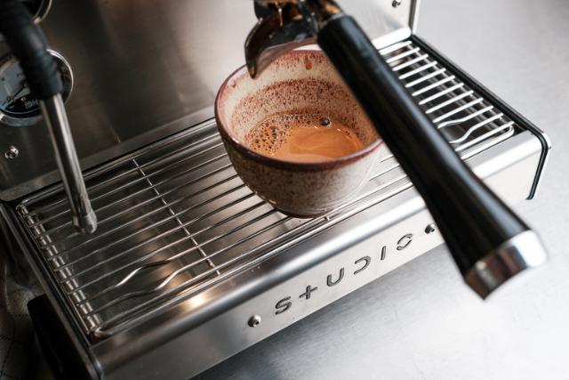 Pige får en kop kaffe på hotellet