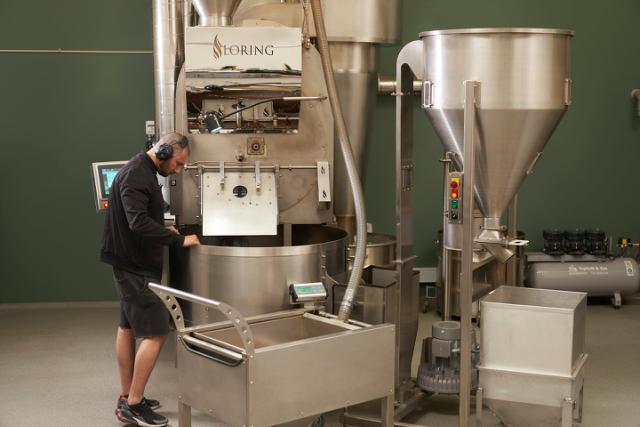 ristemester staar ved sin kafferister og kigger paa kaffeboennerne
