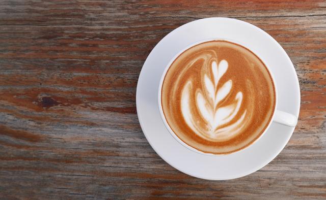 cappuchino i kop med latteart lavet af barista