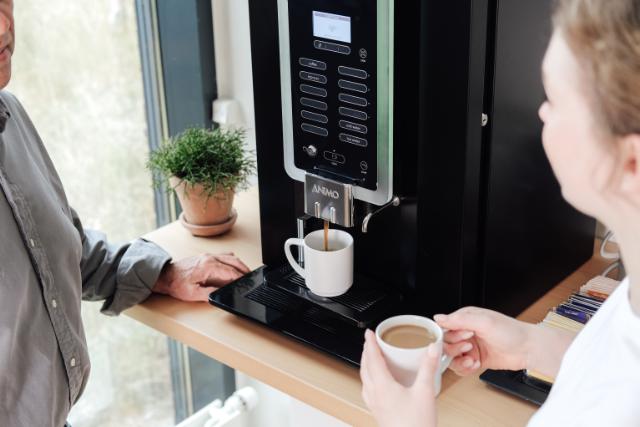 Samtale mellem to kvinder med kaffe i hånden