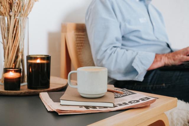 Kaffekop placeret ovenpå notesbog og avis