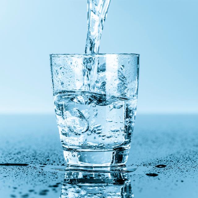 koldt vand bliver hældt i vandglas fra drikkevandskøler