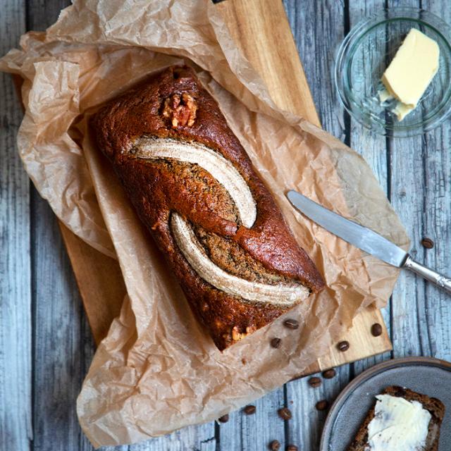bananbrød med kaffe pyntet med hele bananer på toppen