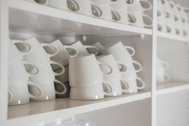 Stakke af hvide kaffekopper klar til kaffeløsningen i virksomheden