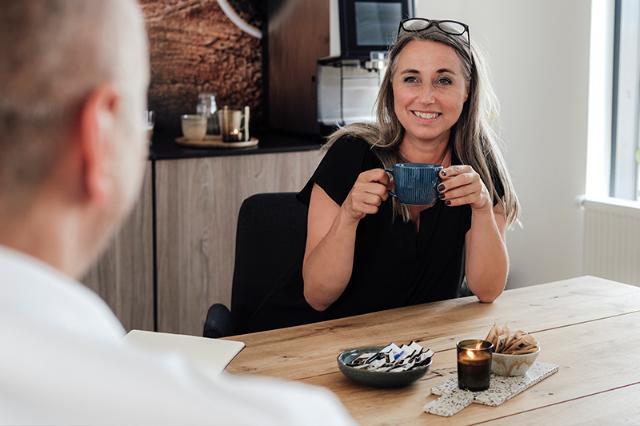 kvinde drikker kaffe og har god medarbejdertrivsel