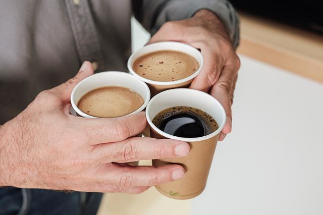 Tre kopper to go kaffer fra kaffemaskine med flydende kaffe