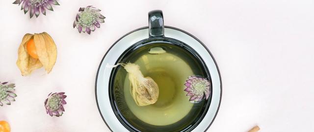 Kop grøn te med blomster