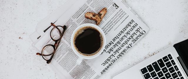 sort kop kaffe på avis ved computer om bki ny webshop